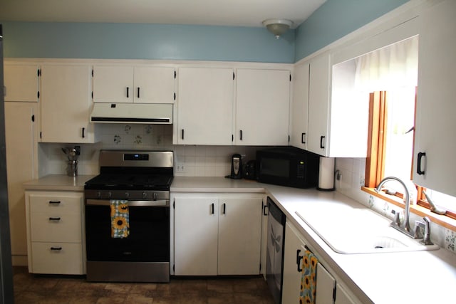 229 Riverside Dr, Hart, MI 49420 - kitchen with stainless steel gas range oven, black microwave, under cabinet range hood, backsplash, and white cabinetry