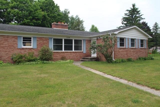 229 Riverside Dr, Hart, MI 49420 - ranch-style home featuring brick siding, a front yard, and a chimney