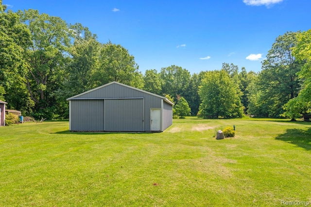 20551 Elwell Rd, Belleville, MI 48111 - view of green lawn featuring a pole building, a detached garage, and an outbuilding