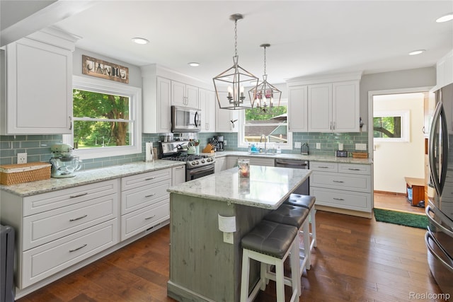 20551 Elwell Rd, Belleville, MI 48111 - kitchen with appliances with stainless steel finishes, backsplash, white cabinets, radiator, and dark wood-style flooring