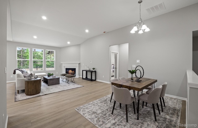 3045 Sheffield Cir, Clarkston, MI 48346 - dining space with wood finished floors, a chandelier, a glass covered fireplace, and recessed lighting