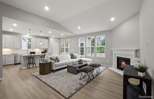 3045 Sheffield Cir, Clarkston, MI 48346 - living room featuring lofted ceiling, light wood-style floors, plenty of natural light, a high end fireplace, and recessed lighting