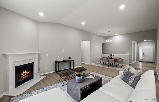 3045 Sheffield Cir, Clarkston, MI 48346 - living room with wood finished floors, a high end fireplace, lofted ceiling, a chandelier, and recessed lighting