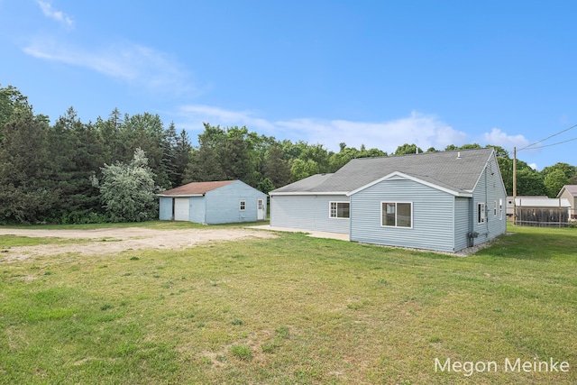 3682 W Long Lake Rd, Orleans, MI 48865 - back of property with a garage, a yard, an outbuilding, and roof with shingles