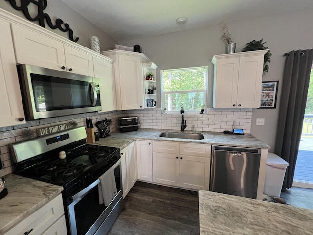 2650 Eagle Rdg, Muskegon, MI 49444 - kitchen featuring appliances with stainless steel finishes, white cabinets, tasteful backsplash, dark wood-style flooring, and light stone counters