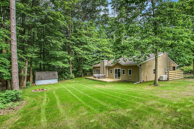 6490 Island Lake Rd, Holland, MI 49423 - view of green lawn featuring a storage shed, a deck, and an outdoor fire pit