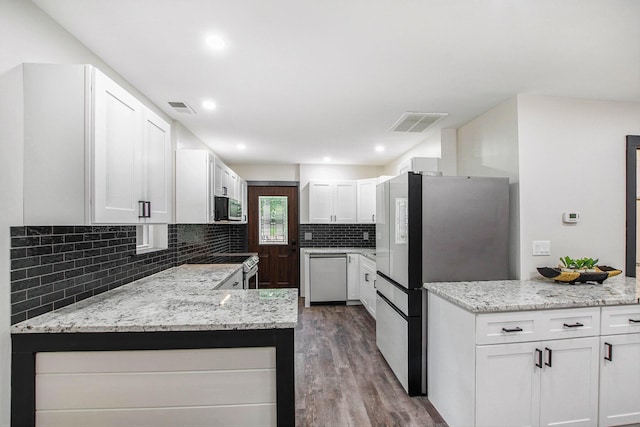 6490 Island Lake Rd, Holland, MI 49423 - kitchen featuring appliances with stainless steel finishes, dark wood-style flooring, backsplash, light stone counters, and recessed lighting