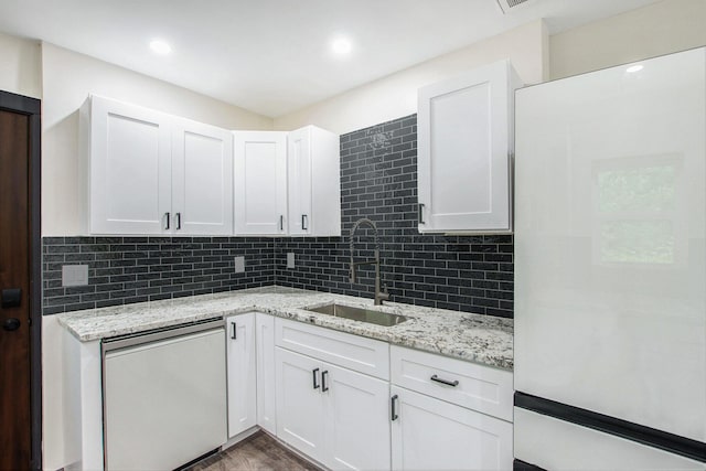 6490 Island Lake Rd, Holland, MI 49423 - kitchen featuring freestanding refrigerator, white cabinets, tasteful backsplash, and light stone countertops