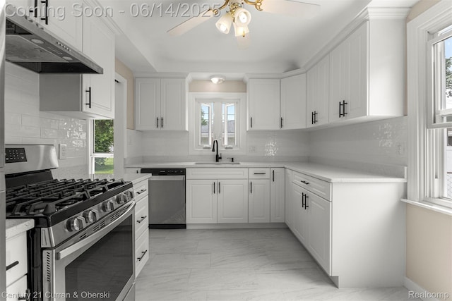 30345 Rush St, Garden City, MI 48135 - kitchen with appliances with stainless steel finishes, under cabinet range hood, ceiling fan, light marble finish floors, and backsplash