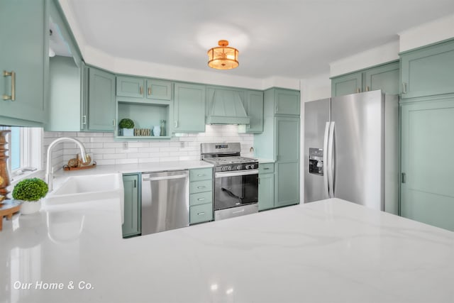 7698 E Holland Rd, Saginaw, MI 48601 - kitchen with appliances with stainless steel finishes, custom range hood, green cabinetry, and decorative backsplash