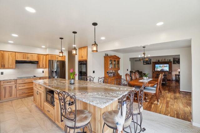 2138 Kennedy Dr, Rochester Hills, MI 48309 - kitchen featuring black appliances, under cabinet range hood, a center island, recessed lighting, and light stone counters