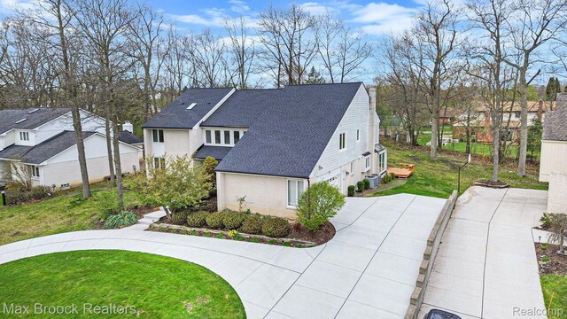 5322 Pond Bluff Dr, West Bloomfield, MI 48323 - view of home's exterior with an attached garage, roof with shingles, a lawn, a residential view, and concrete driveway