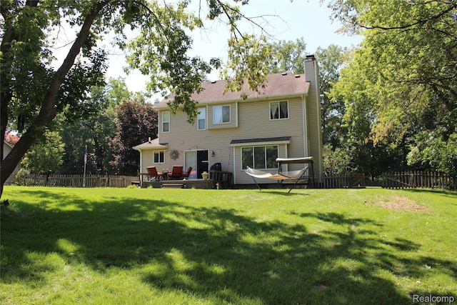14361 Blue Heron Dr, Fenton, MI 48430 - rear view of property featuring a fenced backyard, a chimney, and a wooden deck