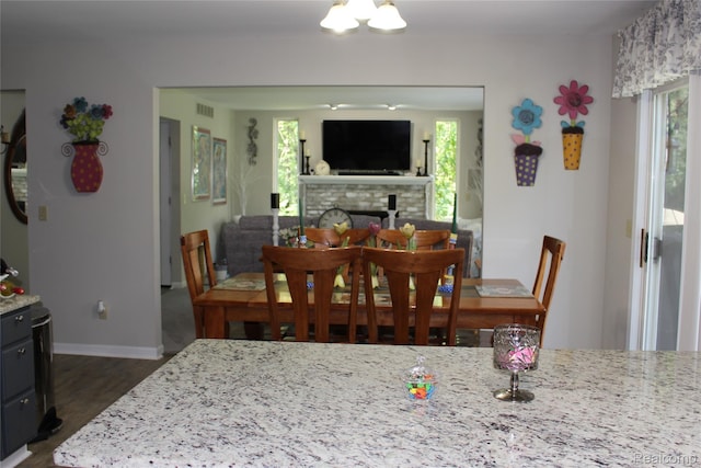 14361 Blue Heron Dr, Fenton, MI 48430 - dining area with dark wood-type flooring and a brick fireplace