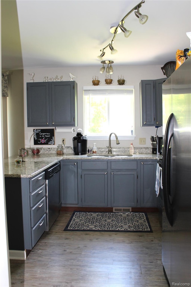 14361 Blue Heron Dr, Fenton, MI 48430 - kitchen with freestanding refrigerator, dishwasher, light stone countertops, light wood-type flooring, and track lighting