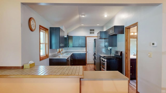 11469 Haven St, Clio, MI 48420 - kitchen featuring stainless steel appliances, light countertops, light wood-style flooring, vaulted ceiling, and a peninsula