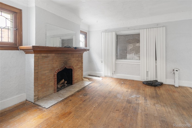 17327 Indiana St, Detroit, MI 48221 - unfurnished living room with wood-type flooring and a brick fireplace