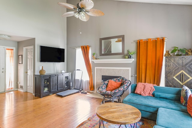 4315 Knollcrest Dr, Ann Arbor, MI 48108 - living area featuring a fireplace, a ceiling fan, wood finished floors, and a towering ceiling