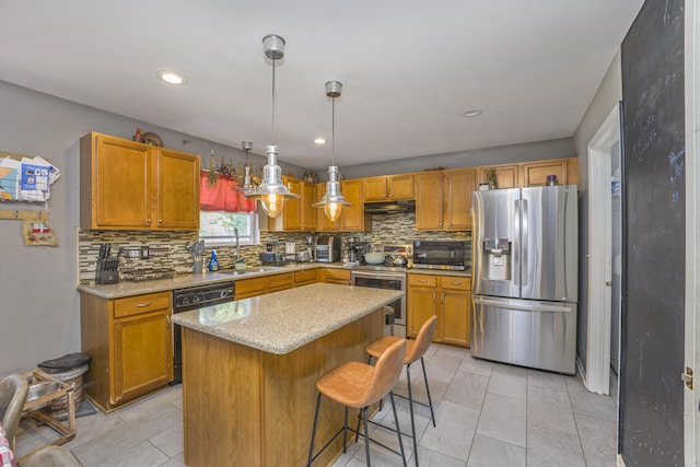 4315 Knollcrest Dr, Ann Arbor, MI 48108 - kitchen with stainless steel appliances, backsplash, under cabinet range hood, hanging light fixtures, and a kitchen island