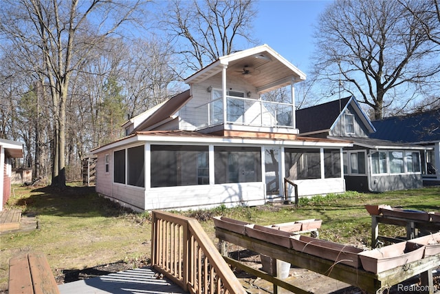 13358 Wendell St, Fenton, MI 48430 - back of house featuring a sunroom, a balcony, ceiling fan, and a lawn