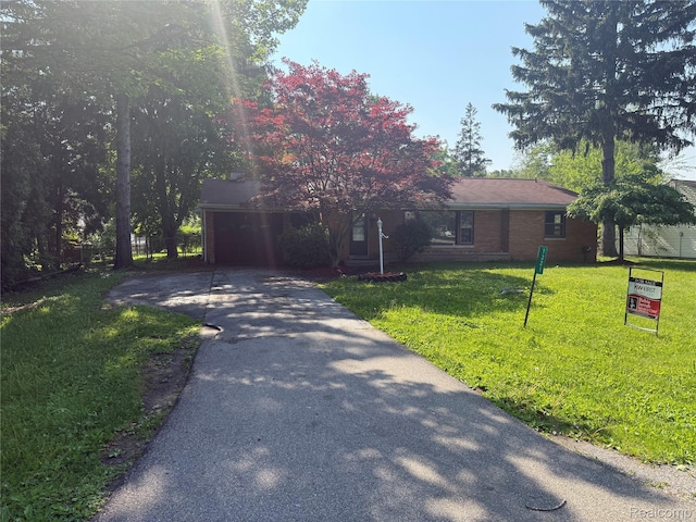 1321 Rainbow Dr, Saginaw, MI 48638 - view of front of house with driveway, a garage, and a front lawn