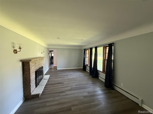 1321 Rainbow Dr, Saginaw, MI 48638 - unfurnished living room with a stone fireplace, dark wood-type flooring, and baseboard heating