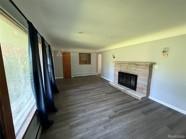 1321 Rainbow Dr, Saginaw, MI 48638 - unfurnished living room featuring a baseboard heating unit, a glass covered fireplace, and dark wood-style flooring