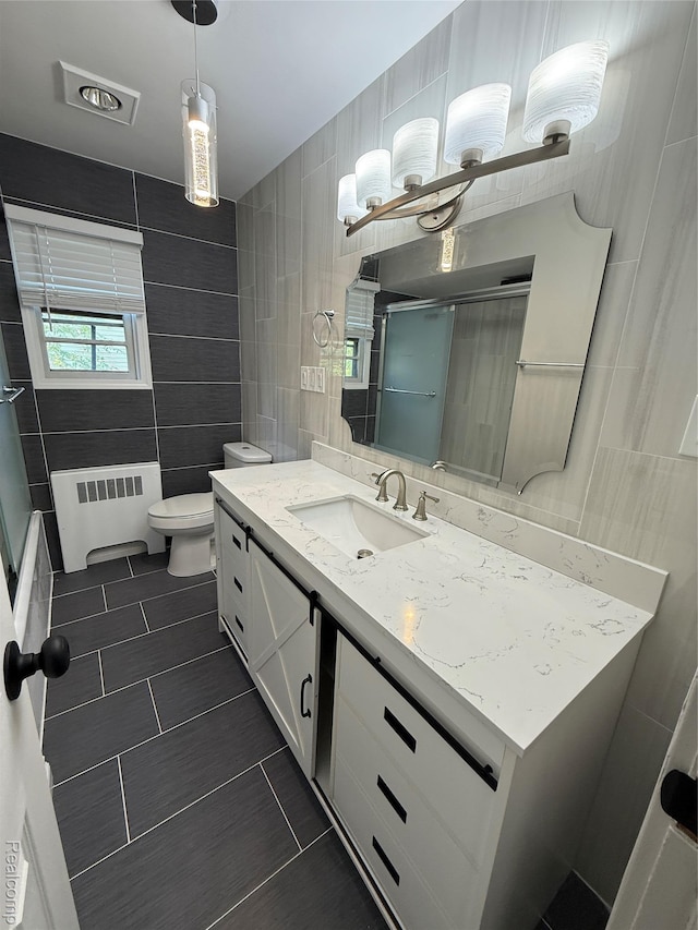 1321 Rainbow Dr, Saginaw, MI 48638 - bathroom featuring tile walls, radiator, tile patterned flooring, vanity, and an enclosed shower