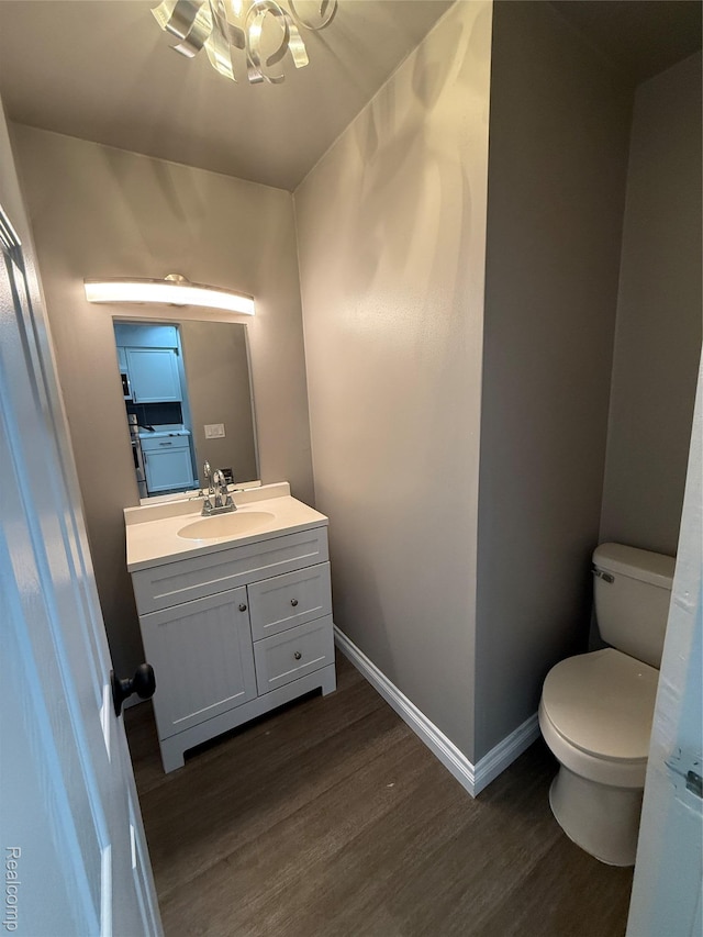 1321 Rainbow Dr, Saginaw, MI 48638 - half bath featuring wood finished floors, vanity, and a chandelier