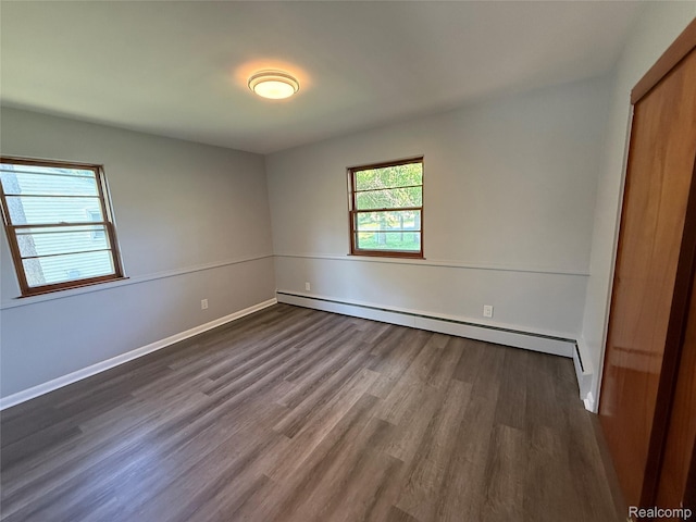 1321 Rainbow Dr, Saginaw, MI 48638 - unfurnished bedroom with a baseboard heating unit and dark wood-style flooring