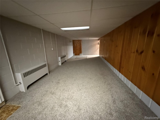 1321 Rainbow Dr, Saginaw, MI 48638 - finished below grade area featuring radiator, light carpet, concrete block wall, a drop ceiling, and wood walls