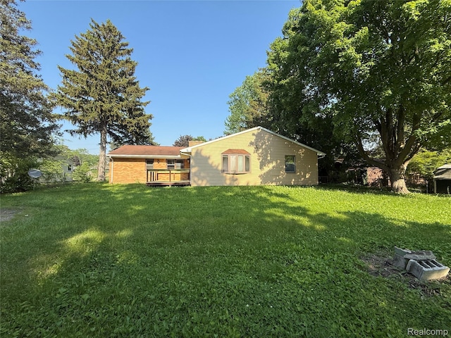 1321 Rainbow Dr, Saginaw, MI 48638 - back of house with a wooden deck and a lawn