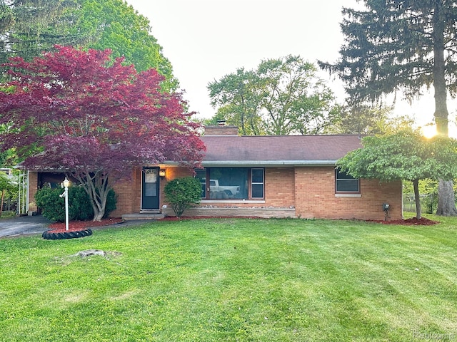 1321 Rainbow Dr, Saginaw, MI 48638 - view of front facade with brick siding and a front yard