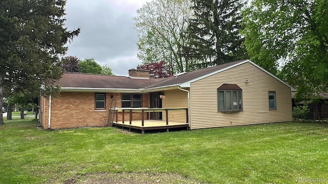1321 Rainbow Dr, Saginaw, MI 48638 - rear view of house featuring a deck, a chimney, a lawn, and brick siding
