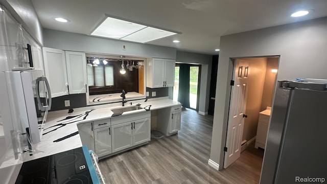 1321 Rainbow Dr, Saginaw, MI 48638 - kitchen with wood finished floors, light countertops, stainless steel refrigerator, recessed lighting, and black electric cooktop