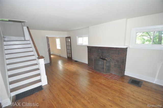 1924 Pinecrest Dr, Ferndale, MI 48220 - unfurnished living room with wood finished floors, stairway, and a brick fireplace
