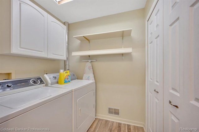 210 Mary St, Flushing, MI 48433 - laundry area with cabinet space, washing machine and clothes dryer, and light wood-style flooring