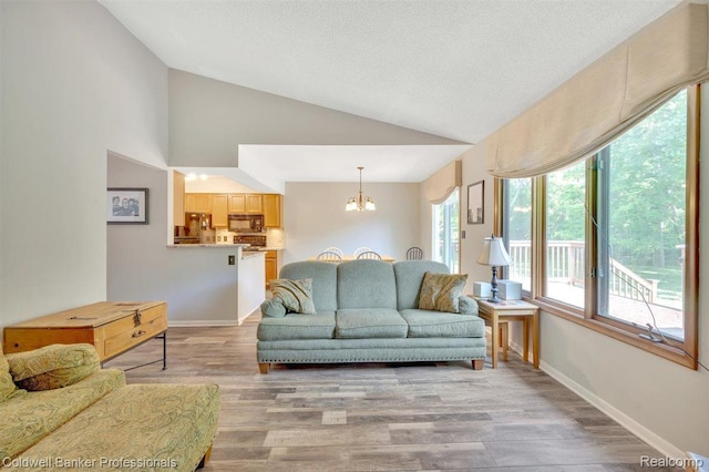 210 Mary St, Flushing, MI 48433 - living area featuring a chandelier, light wood finished floors, high vaulted ceiling, and a textured ceiling