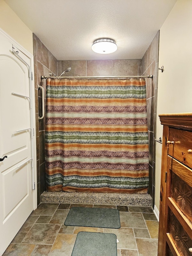 1005 W Lake St, Tawas City, MI 48763 - full bath featuring stone tile flooring, a textured ceiling, and a shower with shower curtain