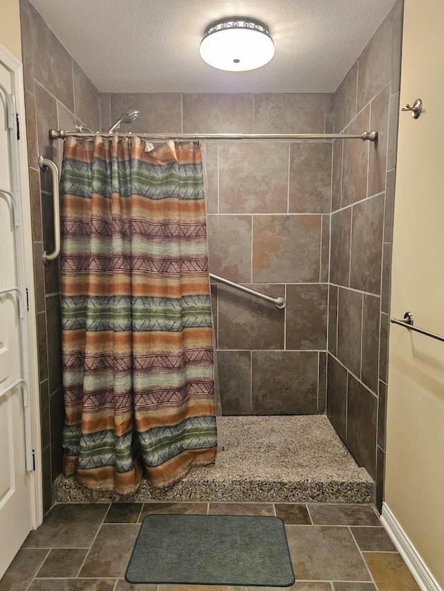 1005 W Lake St, Tawas City, MI 48763 - bathroom with a textured ceiling, tiled shower, and stone finish floors