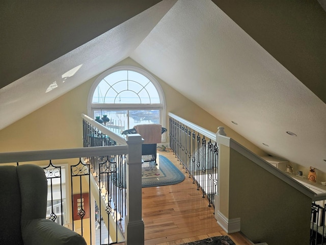 1005 W Lake St, Tawas City, MI 48763 - hallway with lofted ceiling, wood finished floors, an upstairs landing, and a textured ceiling