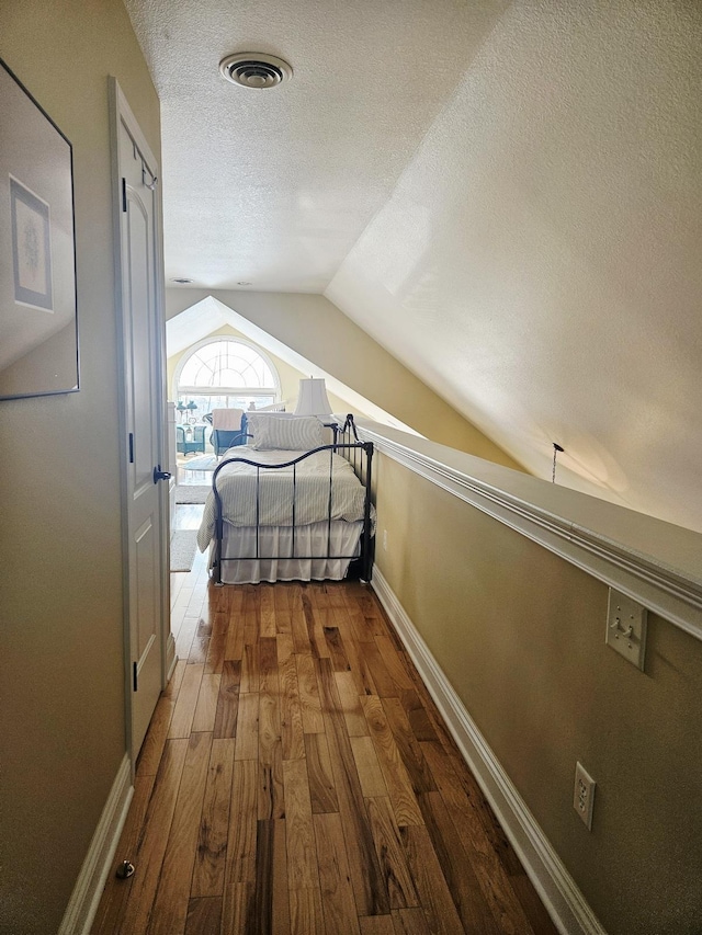 1005 W Lake St, Tawas City, MI 48763 - hallway featuring a textured ceiling, lofted ceiling, and wood-type flooring