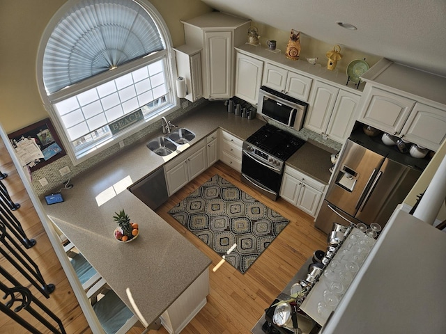 1005 W Lake St, Tawas City, MI 48763 - kitchen featuring appliances with stainless steel finishes, light wood-style flooring, and white cabinets