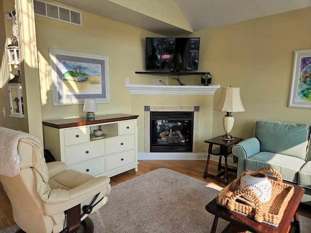 1005 W Lake St, Tawas City, MI 48763 - living area with wood finished floors, a glass covered fireplace, and vaulted ceiling