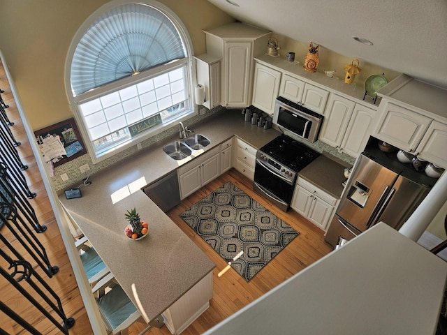 1005 W Lake St, Tawas City, MI 48763 - kitchen with stainless steel appliances, light wood-type flooring, and white cabinets