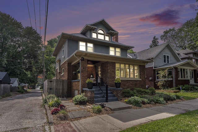 643 Giddings Ave SE, Grand Rapids, MI 49506 - american foursquare style home featuring brick siding, asphalt driveway, a porch, and stucco siding