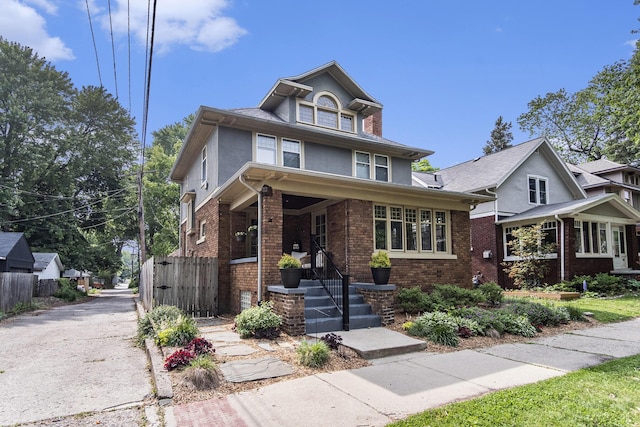 643 Giddings Ave SE, Grand Rapids, MI 49506 - traditional style home featuring brick siding, stucco siding, covered porch, and driveway