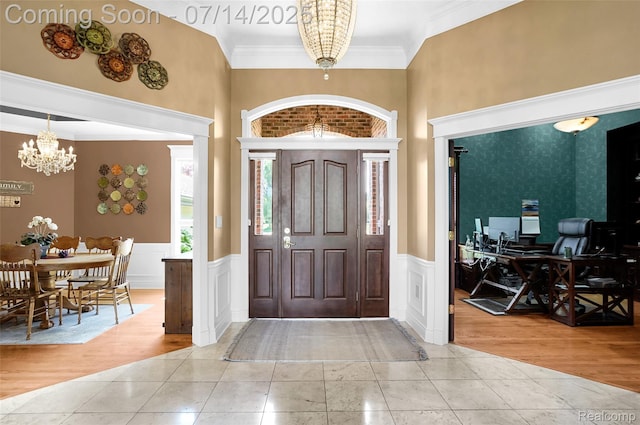 2985 Dana Pointe Dr, Pinckney, MI 48169 - entryway with a chandelier, light tile patterned floors, crown molding, wainscoting, and a high ceiling