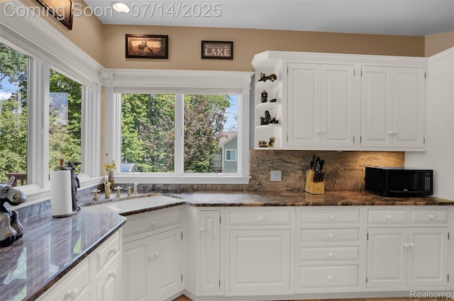 2985 Dana Pointe Dr, Pinckney, MI 48169 - kitchen with black microwave, white cabinetry, dark stone counters, tasteful backsplash, and open shelves