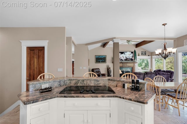 2985 Dana Pointe Dr, Pinckney, MI 48169 - kitchen with black electric cooktop, open floor plan, a fireplace, a chandelier, and decorative light fixtures